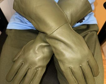 May include: Olive green leather gloves with long cuffs. The gloves are made of a smooth, supple leather and appear to be new. The gloves are designed to protect the hands and forearms.
