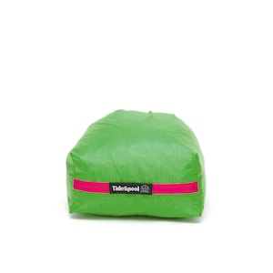 May include: A green waterproof dry bag with a pink reflective strip and the text "Tidepool" printed on it.