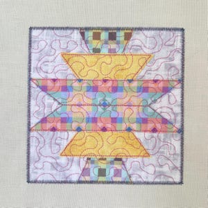 May include: A square fabric quilt block featuring a central geometric star pattern in yellow and a multi-coloured checkered print. The design is overlaid with red meandering machine quilting stitches on a white background with a dark zigzag border.