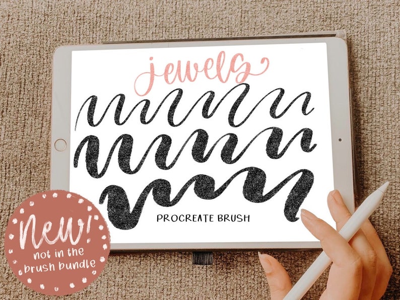 May include: A digital illustration of a Procreate brush called "jewelry" on a tablet screen. The brush is used to create a series of black cursive "m" letters. The tablet is on a brown surface. The text "New! Not in the brush bundle" is in a pink circle on the left side of the image.