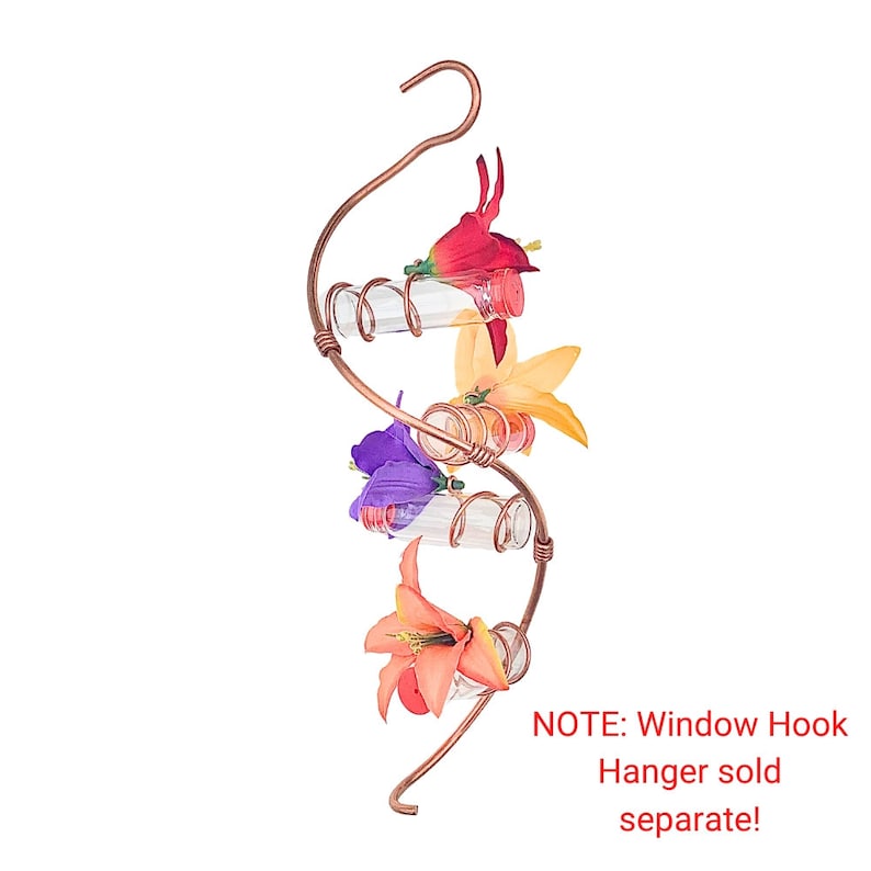 May include: A copper-colored, spiral-shaped hummingbird feeder with clear glass tubes and colorful artificial flowers. The feeder has a hook for hanging and is designed to attract hummingbirds. The flowers are red, orange, yellow, and purple.