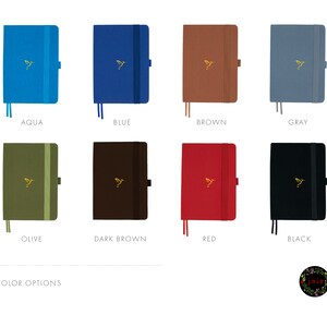 May include: A selection of eight different colored notebooks with a gold hummingbird logo. The colors are aqua, blue, brown, gray, olive, dark brown, red, and black.