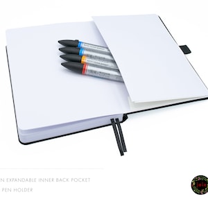 May include: A black notebook with an expandable inner back pocket and a pen holder. The notebook is open and has a white interior. There are four markers in the pocket, including a blue, orange, and two grey markers. The markers have the text "Winsor Newton Water Colour Markers" printed on them.