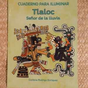 May include: A softcover book with the title "CUADERNO PARA ILUMINAR Tlaloc Señor de la lluvia" in teal and black. The cover features a colorful illustration of a deity with intricate details. The author's name, Corinna Rodrigo Enriquez, is at the bottom.