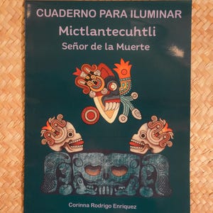 May include: A dark teal book cover with the title "CUADERNO PARA ILUMINAR" and the name "Mictlantecuhtli, Señor de la Muerte" in white text. The cover features illustrations of a skull and a deity mask in orange, red, and teal.
