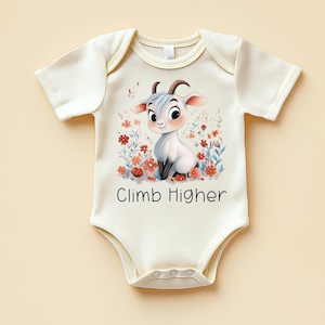 May include: Cream-colored baby bodysuit with a cartoon goat illustration surrounded by flowers. The goat has blue hair and is sitting in a field of red and blue flowers. The text "Climb Higher" is printed below the goat.