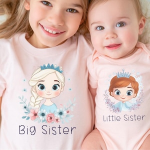 May include: Two light pink shirts with matching graphics. One shirt says "Big Sister" and features a cartoon princess with a blue crown and blonde braid. The other says "Little Sister" and has a cartoon princess with a crown and red hair.