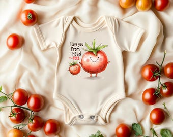 May include: Cream-colored baby onesie with a tomato graphic and the text "I Love you From Head to Toes." The onesie is surrounded by fresh red and yellow tomatoes on a cream-colored fabric.