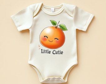 May include: Cream baby bodysuit featuring a smiling orange illustration with green leaves and the text "Little Cutie". The onesie has short sleeves and poppers at the bottom. The orange has blush cheeks.