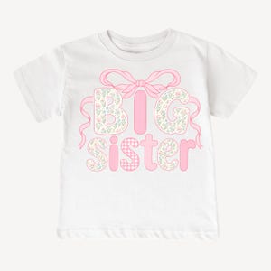 May include: White t-shirt with the words "BIG sister" in pink. The letters "B" and "G" are filled with a floral pattern, while the "I" is solid pink. The "S" and "E" are floral, and the "T" and "R" are pink gingham.