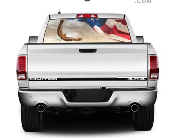 Op de afbeelding: Een witte pick-up truck met een sticker op de achterruit met een Amerikaanse vlag en een bald eagle die erboven vliegt. De truck heeft een "LIMITED" en "4X4" embleem op de achterklep.