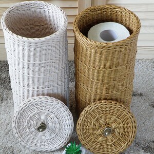 Puede incluir: Dos cestas tejidas con tapas, una blanca y otra marr&oacute;n, para guardar rollos de papel higi&eacute;nico. Las cestas est&aacute;n hechas de materiales naturales y tienen un aspecto r&uacute;stico.