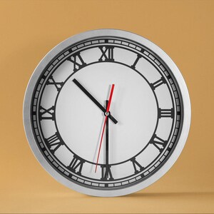 May include: A silver clock with black Roman numeral markings and black hour and minute hands. The clock has a white face and a red second hand.