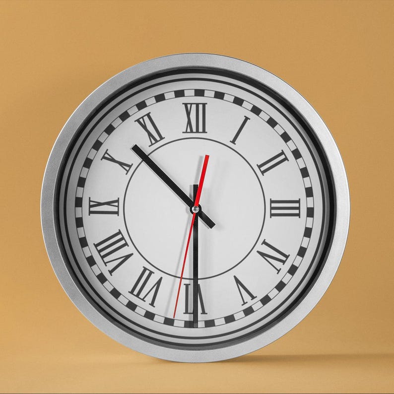 May include: A silver-framed clock with Roman numeral markings and black hour and minute hands. The clock face is white with black markings and a red second hand.