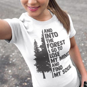 May include: White t-shirt with a black and gray graphic of a forest with the text "AND INTO THE FOREST I GO TO LOSE MY MIND AND FIND MY SOUL".
