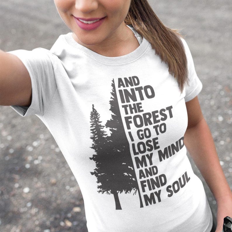 May include: White t-shirt with a black and gray graphic of a forest with the text "AND INTO THE FOREST I GO TO LOSE MY MIND AND FIND MY SOUL".