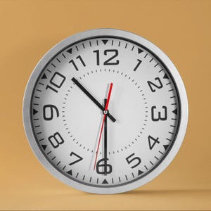 May include: A silver-framed clock with black numbers and hands. The clock face is white with a red second hand. The clock is set to 12:00.