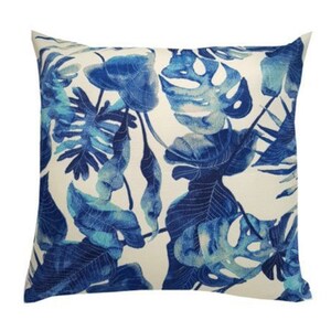 May include: A white cushion with a blue and teal tropical leaf pattern.