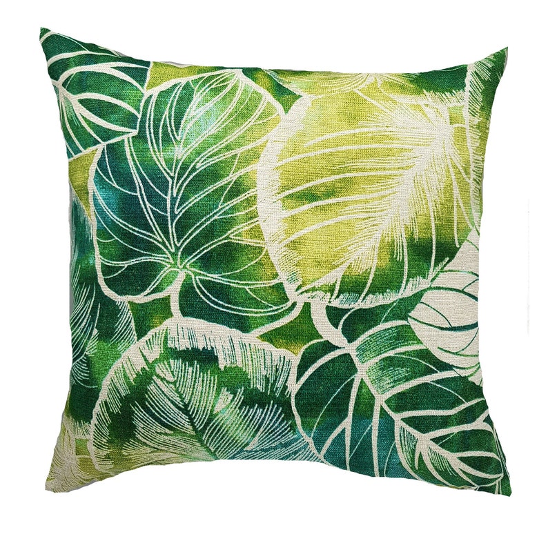 May include: Green and white throw pillow with a leafy pattern. The pillow is made of a soft, textured fabric.