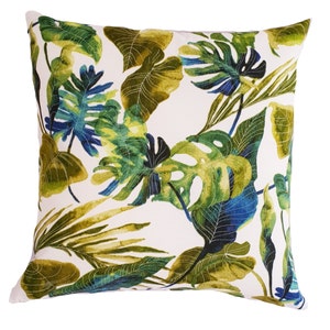 May include: A white cushion with a tropical leaf pattern in shades of green and blue.