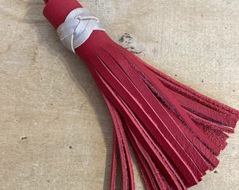 Long pompon porte-clé en cuirs rouge et or pâle.