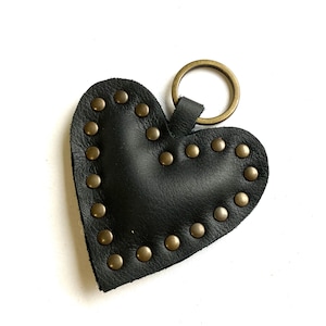 May include: Black leather heart-shaped keychain with gold-toned studs and a metal ring.