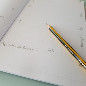 May include: A blank page in a notebook with the words "Ideas for tomorrow" and "Lists" written in cursive. A yellow pencil with a black eraser is lying on the page.