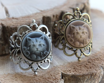 May include: Two silver rings with a cameo design featuring a cat's face. The rings have a delicate, ornate design.