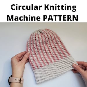 Pode incluir: Um gorro de malha listrado em branco e rosa, segurado por mãos. O chapéu é feito com uma máquina de tricô circular. O texto na parte superior diz "Circular Knitting Machine PATTERN".