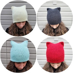 May include: Four knitted hats with cat ears. The hats are in different colors: light yellow, black, light blue, and red.