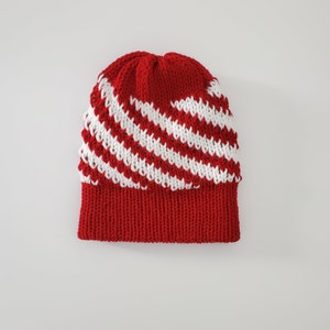 May include: Red and white knitted beanie with a striped pattern.