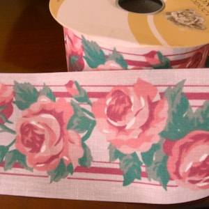 Peut inclure: Ruban floral rose et vert avec des rayures rouges et blanches. Le ruban présente un motif répété de roses roses avec des feuilles vertes.