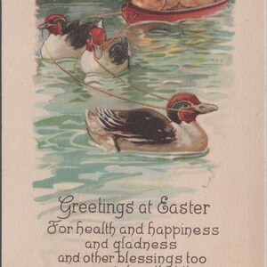May include: A vintage postcard illustration featuring three ducks swimming in water, pulling a red canoe filled with four yellow ducklings. The text reads: Greetings at Easter, For health and happiness and gladness and other blessings too are my wishes that this Easter time brings to You.