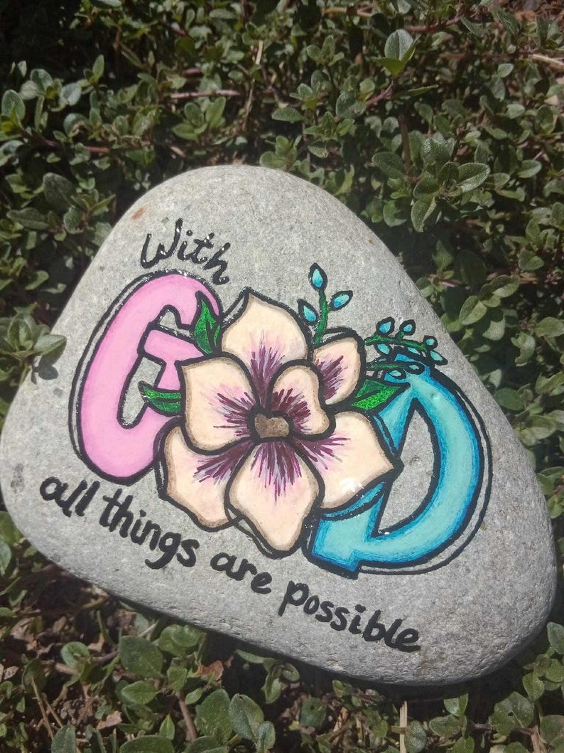 Painted rock that says "With God, All Things Are Possible"