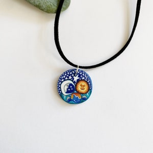 Vintage double sided fimo clay pendant with a sun and moon on a starry background with dolphin and a tree with a faux suede necklace rope