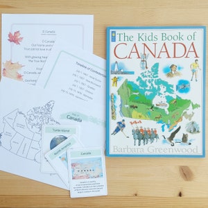 May include: A colourful children's book about Canada with a map of the country, illustrations of animals, and a timeline of Confederation. The book cover features the title "The Kids Book of CANADA" in large, bold letters with a red maple leaf.
