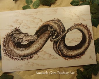 May include: A sepia-toned print of a dragon in a looping pose, set against a cloudy sky. The dragon is detailed with textured scales and a serpentine form. The artist's name, "Amanda Gera Fantasy Art," is printed at the bottom.