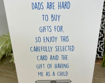 May include: A white card with blue text that reads "Dads are hard to buy gifts for, so enjoy this carefully selected card and the gift of having me as a child".
