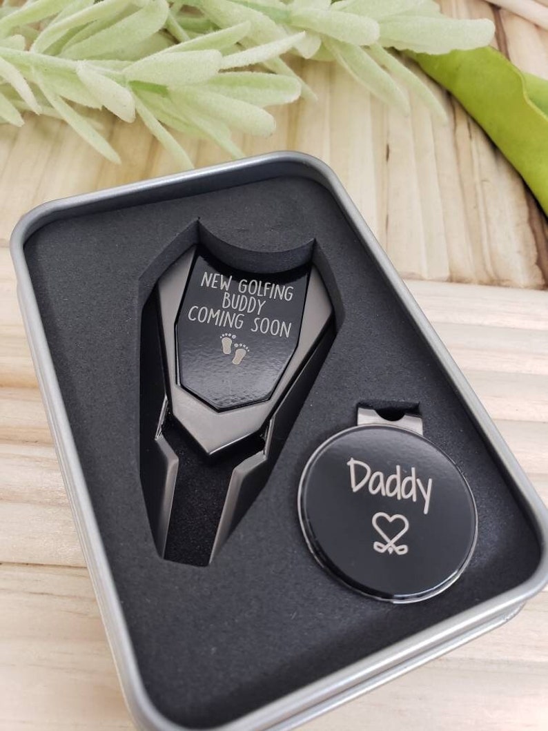 Golf Divot Tool Set comes with the quote " New golfing buddy coming soon". The magnetic marker comes complete with a hat clip.