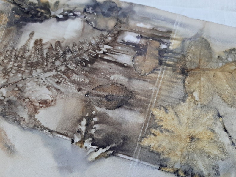 May include: A close-up of a piece of fabric with a brown and gold leaf pattern. The fabric has a textured surface and appears to be made of natural fibers.