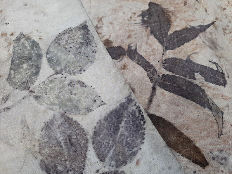 May include: A close-up of two pieces of fabric with leaf prints. The fabric on the left has a light green leaf print, while the fabric on the right has a darker brown leaf print.