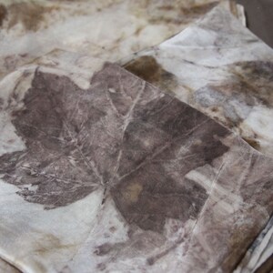 May include: A set of three silk scarves with a natural dye pattern of leaves in shades of brown and beige.