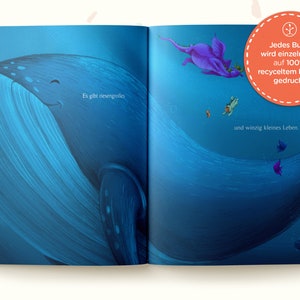 May include: An open book with an illustration of a whale and a purple dragon in the ocean. The text on the page reads "Es gibt riesengrolles" and "und winzig kleines Leben." The book cover has a red circle with a plant icon and the text "Jedes Buch wird einzeln und auf 100% recyceltem Papier gedruckt."