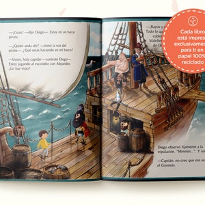 May include: An open children's storybook featuring a colorful illustration of a wooden pirate ship on the ocean. The scene depicts a child in a yellow shirt interacting with a pirate captain and crew. Text in Spanish is printed on the pages.