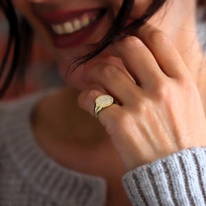 Diamond pinky ring on a woman's hand