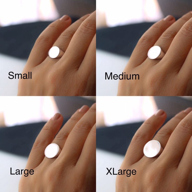 May include: Four silver signet rings in different sizes: small, medium, large, and extra large. The rings are shown on a hand, with the size label below each ring.