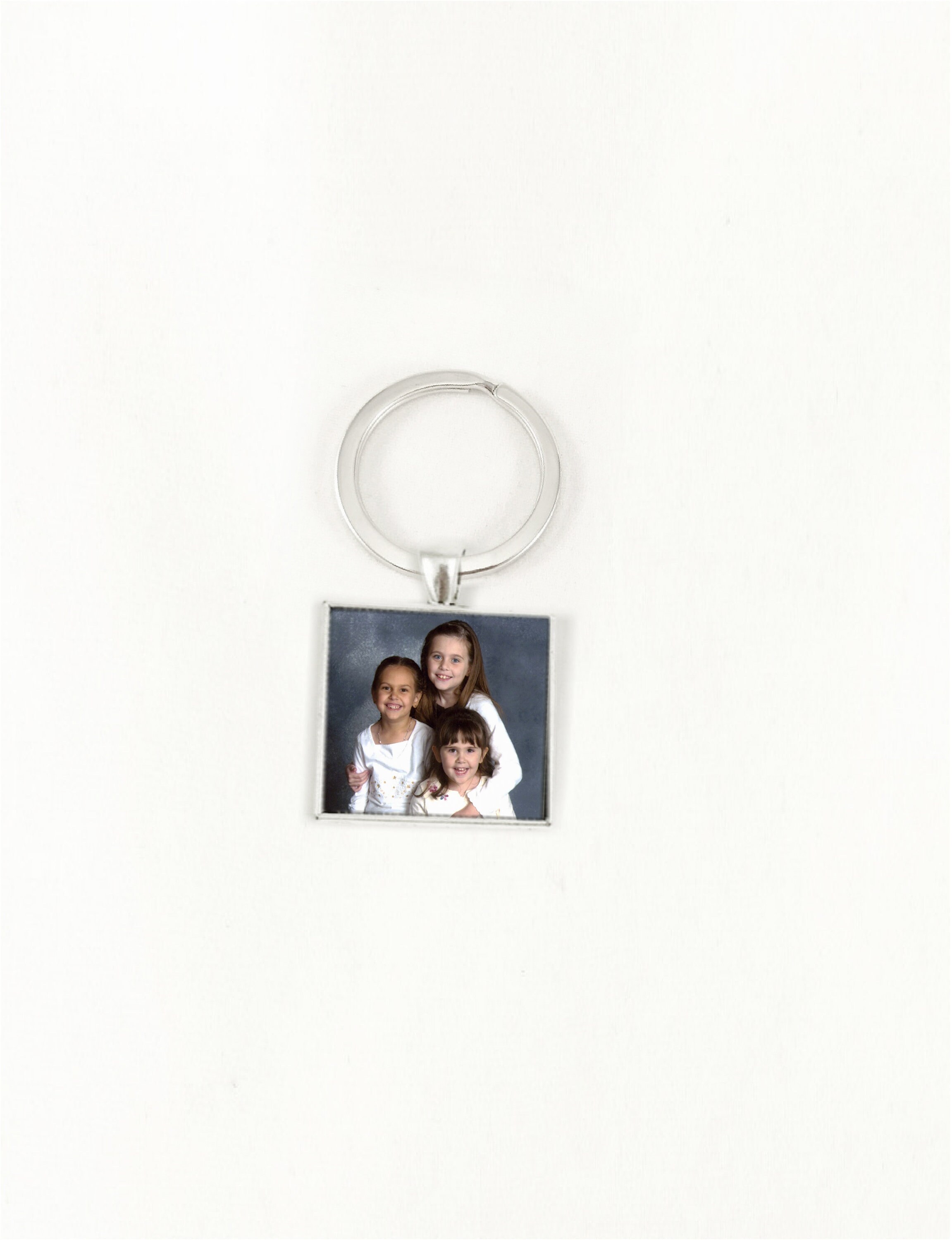 Photo keychain personalized with a picture, set in a metal charm of your choice, secured with glass
