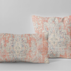 May include: Two decorative throw pillows with a vintage floral pattern in shades of coral, cream, and blue.