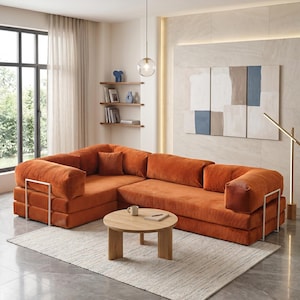 Puede incluir: Un sof&aacute; seccional naranja con detalles met&aacute;licos. Una mesa de centro redonda de madera descansa sobre una alfombra crema. La habitaci&oacute;n tiene un dise&ntilde;o moderno, una ventana grande y obras de arte abstractas.