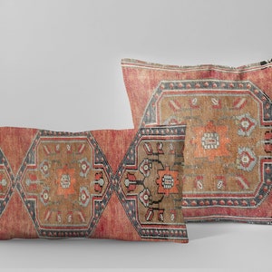 Puede incluir: Dos cojines decorativos con un diseño estampado en rojo, naranja y azul inspirado en alfombras turcas tradicionales.